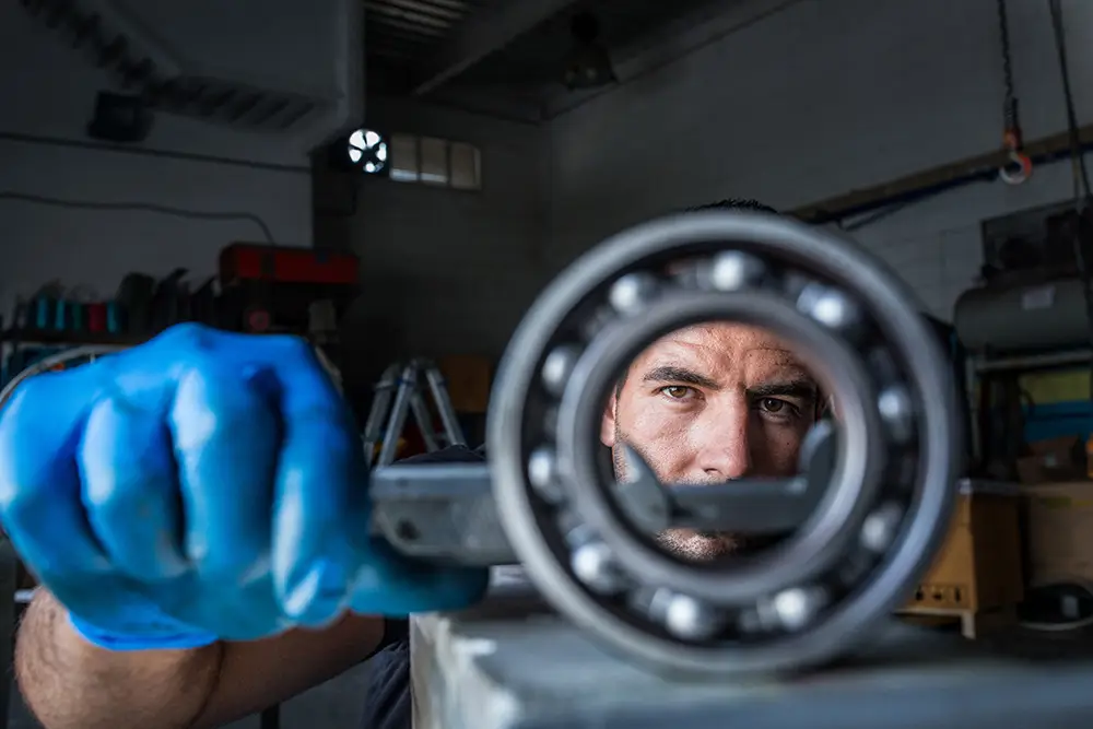 Tekniker kontrollerar kullager i industriell miljö vid underhåll